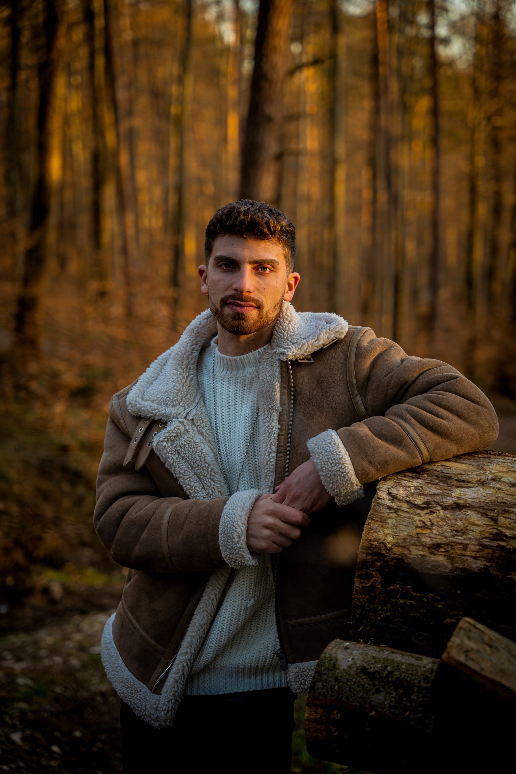 Luis Grau im Wald, an einen Baumstamm gelehnt, Blick in die Kamera